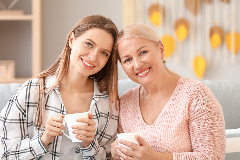 Mature woman and her adult daughter spending time together at home 