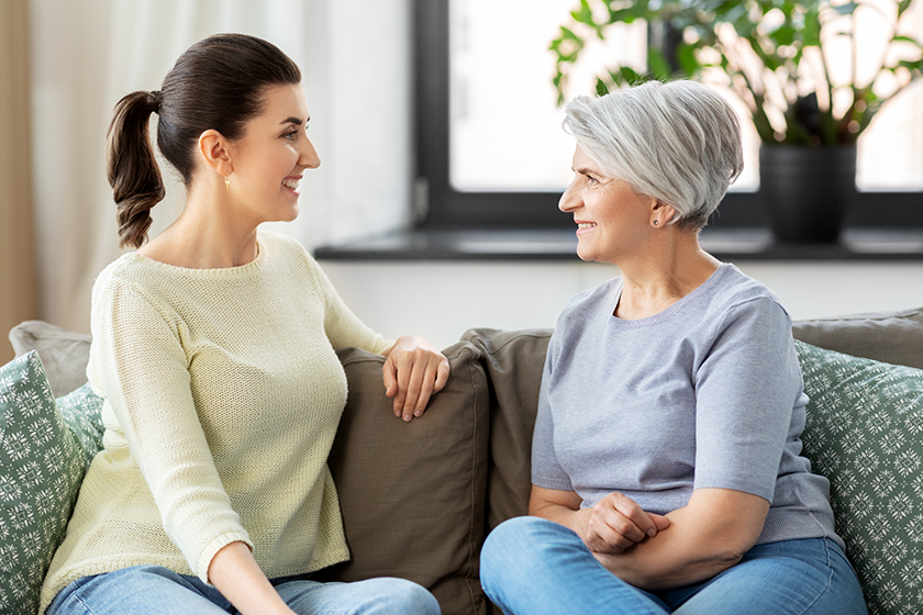 Senior mother with adult daughter talking at home 